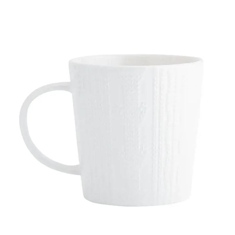 Biała ceramiczna kubek z teksturą, idealny do kawy lub herbaty w domu.