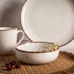 Ceramiczny zestaw obiadowy z brązową obwódką, kubek i miska na naturalnym tle, idealny do domu i kawiarni, styl rustykalny, elegancki design.