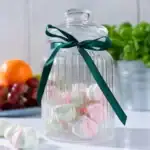 Liściki z miętowych i różowych marshmallows w szklanym słoiku z zieloną wstążką, idealne na domowe słodkości, dekoracje i prezenty.