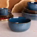Ceramiczne miski i filiżanki w stylu boho, niebieskie z złotymi detalami, idealne do serwowania potraw i napojów, ozdoba kuchni i jadalni, ręcznie robione, eleganckie i praktyczne.