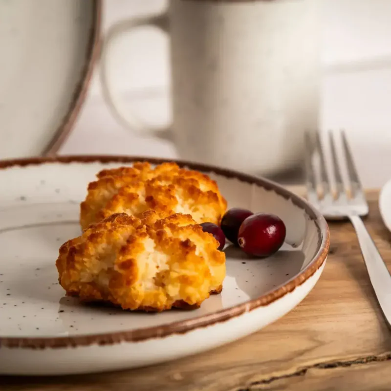 Pieczone kotlety z kurczaka z rożkiem na talerzu, podane z czerwonymi jagodami, rustykalny drewniany blat, inspirowane domowym jedzeniem, zdrowe i smaczne posiłki.