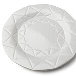 Delikatny biały talerz ceramiczny z geometrycznym wzorem na brzegu, idealny do serwowania potraw i dekoracji stołu.