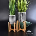 Praktyczne osłony na doniczki z unikalnym wzorem w czarno-białej kolorystyce, ustawione na drewnianych podstawach, idealne do dekoracji wnętrz w stylu nowoczesnym i eleganckim.