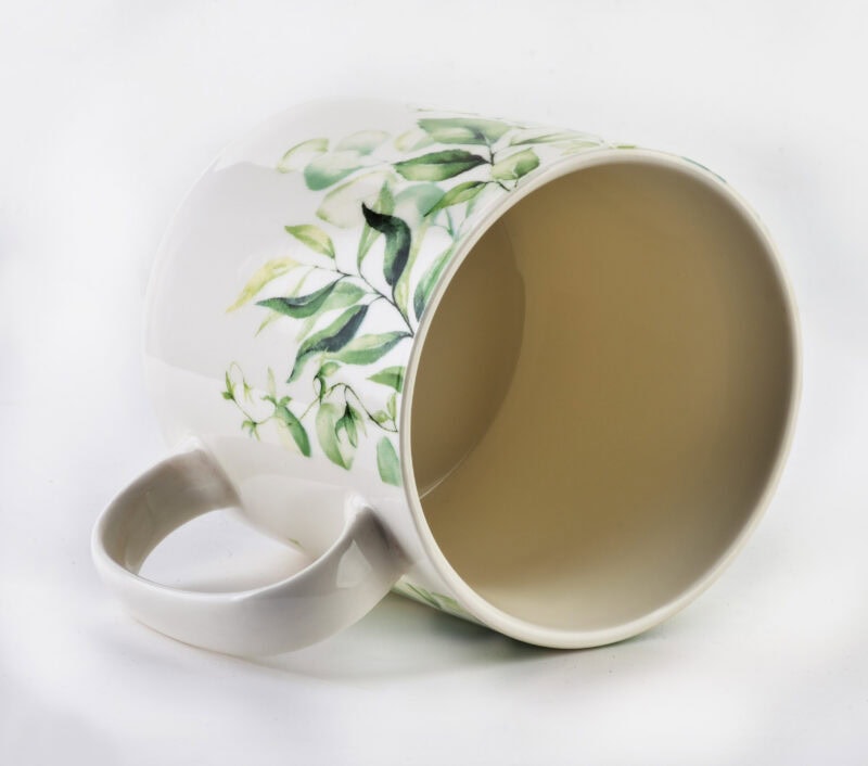 Delikatny kubek z kwiatowym wzorem, idealny do kawy i herbaty, eleganckie naczynie ceramiczne z motywem roślinnym, domowa zastawa stołowa, nowoczesne wnętrza i stylowy dodatek do kuchni.