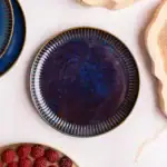 Okładka ceramiczna w głębokim odcieniu niebieskiego z złotymi detalami, elegancka zastawa do serwowania potraw, kolekcja Domowy Zakątek, stylowe naczynie na okazje specjalne i codzienne posiłki.