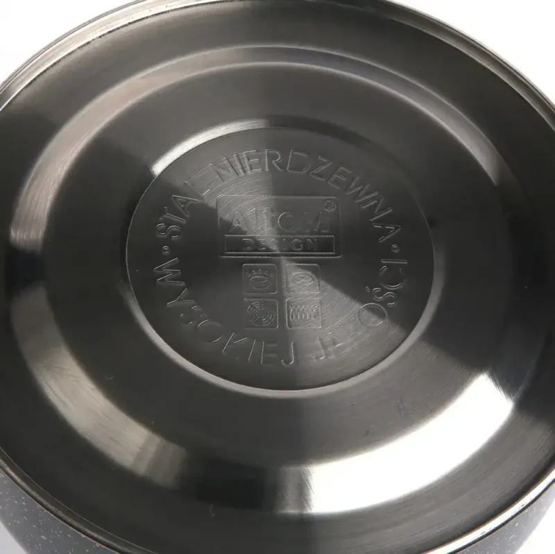 Stalowa pokrywa do garnków i patelni, wysokiej jakości naczynie kuchenne, emblem z oznaczeniem bezpieczeństwa i trwałości, nowoczesny design, idealne do użytku codziennego w domu, odporne na zarysowania i korozję.