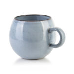Ceramiczny kubek w pastelowym odcieniu niebieskiego, idealny do kawy lub herbaty, w stylu vintage.