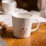 Delikatna ceramiczna filiżanka z zimowym motywem śnieżynek, idealna na poranną kawę czy herbatę, idealna do domowego zacisza, elegancko zdobiona i praktyczna.