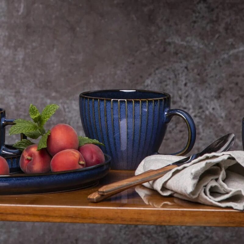 Szklanka z czereśniami, ceramiczny kubek, naczynia na rustykalnym stole, filiżanka na czekanie, naturalny wystrój kuchni, dekoracje do domu, rustykalne naczynia złote, elegancka zastawa, styl domowy, akcesoria kuchenne domowy zakątek.