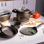 Nowe naczynia kuchenne, garnki i patelnie na kuchennym blacie w nowoczesnej aranżacji kuchni. Idealne do gotowania i przygotowywania posiłków w domu.
