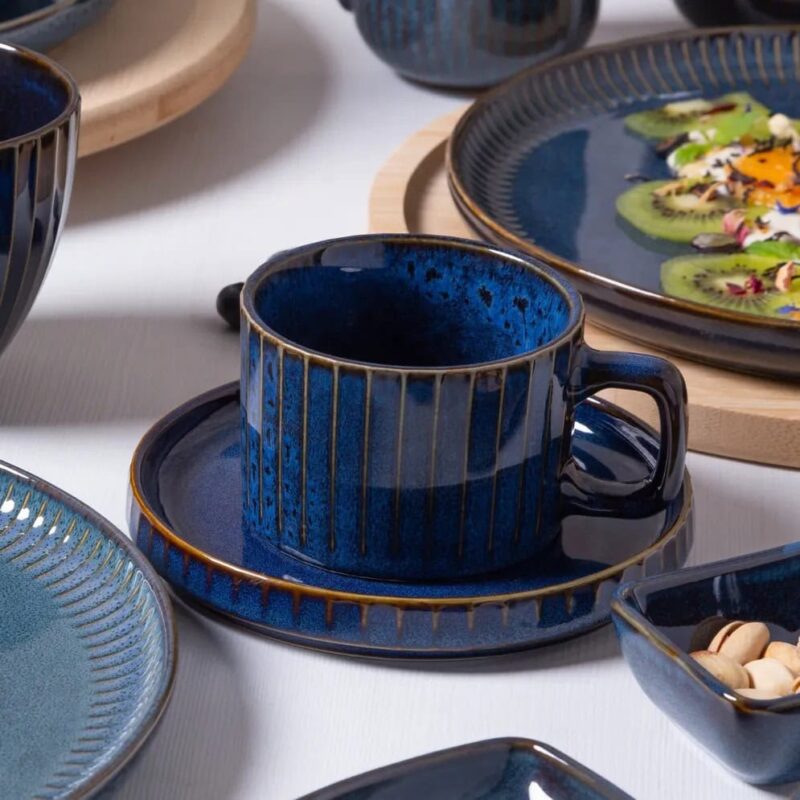 Ceramiczna filiżanka na talerzyku w stylu rustykalnym, głęboki niebieski kolor, idealna do kawy lub herbaty, elegancki dodatek do domu i restauracji.