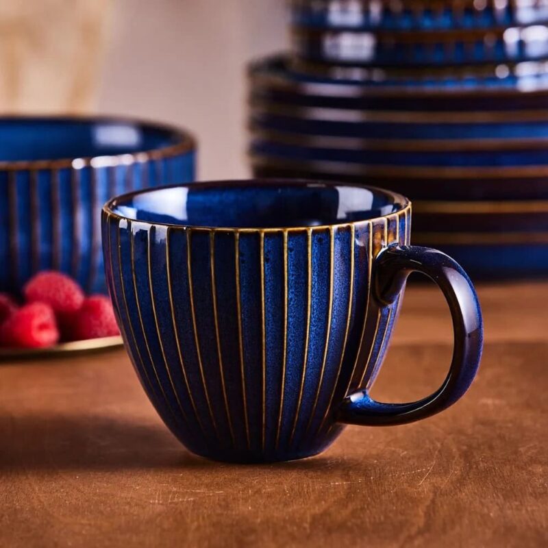 Ceramiczna filiżanka w granatowym kolorze z złotymi pionowymi prążkami, idealna do kawy i herbaty, elegancki dodatek do domu, Domowy Zakątek.