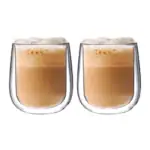 Pełne szklanki kawy z pianką, dwa napoje na białym tle, gorąca kawa latte w eleganckich szklankach.