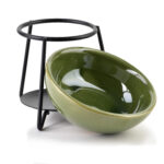 Elegancka zielona miska ceramiczna na przekąski z nowoczesną metalową podstawą, idealna do domowego zacisznego wnętrza, podkreśla aromat i smak potraw.