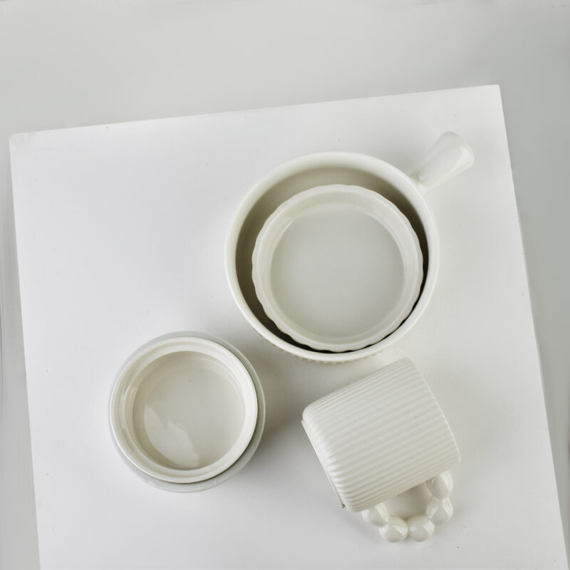 Biały ceramiczny zestaw filiżanek i miseczek na białej powierzchni, idealny do kawy i herbaty w domowym zaciszu, eleganckie naczynia do codziennych i okazjonalnych posiłków w domu, Domowy Zakątek.