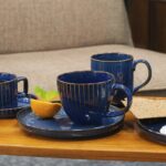 Elegancka porcelanowa zastawa w głębokim niebieskim odcieniu z złotymi paskami, idealna do kawy, herbaty i codziennych chwil relaksu w Domowym Zakątku.