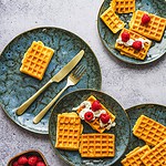 Sztuka domowego śniadania z waflami i malinami na stylowych talerze.