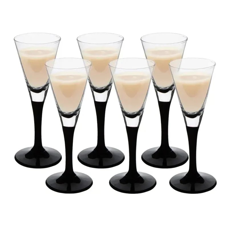 Sześć kieliszków z likierem Baileys na białym tle.