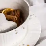 Cynamon, skórka pomarańczy i goździki w świątecznym naczyniu, idealne na domowe aromatyczne przyprawy do zimowych wypieków i napojów, dekoracja na Boże Narodzenie.