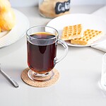Orzechowa herbata w szklanym kubku na drewnianej podkładce z tabliczką z napisem Czubek, śniadanie z owocami, goframi i herbatą na białym tle, idealne na spokojny poranek, domowy zakątek.