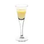Świeży likier cytrynowy w eleganckiej szklance, perfekcyjny do domowych degustacji i aromatycznych napojów, idealny na zimowe wieczory i wyjątkowe okazje.