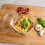 Świeży zestaw składników na sałatkę z mozzarellą, pomidorkami cherry, bazylią, czosnkiem i ziemniakami na drewnianej tacce. Idealne do zdrowego i smakowitego domowego obiadu.