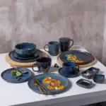 Nowe, eleganckie naczynia z ceramiki w odcieniach granatu i złota, idealne do codziennego użytku i eleganckich okazji w domu. Wyglądają stylowo i są wytrzymałe, doskonałe do serwowania potraw i napojów.