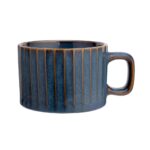 Elegancki ceramiczny kubek w niebieskiej kolorystyce z żłobieniami, idealny na kawę lub herbatę, element wystroju wnętrza domowego zakątka.