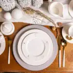 Pastelowe dekoracje świąteczne na stół, eleganckie zastawy i złote sztućce, idealne na bożonarodzeniowy stół, zimowa aranżacja z eleganckim designem, dekoracje na święta, bożonarodzeniowa dekoracja stołu.