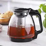 Sokowirówka w stylu retro na jasnym stole z kawałkami cytryny i świeżą bazylią w tle, idealna do przygotowania soku z owoców i warzyw, funkcjonalny i elegancki sprzęt kuchenny Domowy Zakątek.