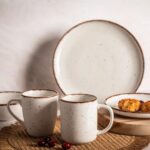 Ceramiczna zastawa stołowa w naturalnym stylu, filiżanki i talerze z białej gliny z brązowymi krawędziami, idealne dla miłośników domowego wnętrza i rustykalnego designu.