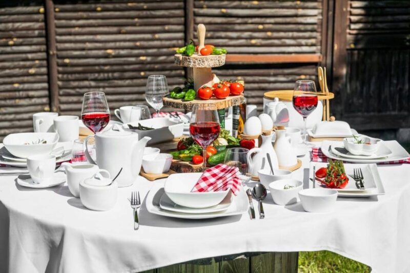 Świąteczny stół z jadalni z naturalnymi dekoracjami, świeżymi warzywami, jajkami i czerwonym winem, idealny do domowego zacisza i przyjęć w stylu domowego zakątka.