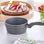 Garnkuchen do gotowania na kuchni domowej, idealny do przygotowywania posiłków, z ciemnoszarnego, pękatego wykończenia, na białym blacie kuchennym.