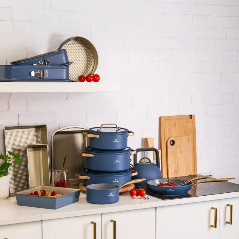 Blaszane i ceramiczne naczynia kuchenne w kolorze granatowym, idealne do gotowania i dekoracji w kuchni domowego zakątka. W Komplet wchodzi patelnia, garnek, rondel i naczynia do pieczenia.